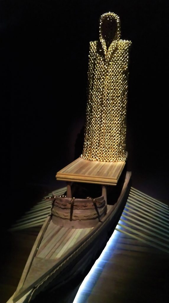 Titarubi, History Repeats Itself, 2016 Gold-plated nutmeg, copper-plated wood, nickle-plated wood, burnt wood, sampan, wood, aluminium, copper, soil, light and nutmeg perfume. Image courtesy author