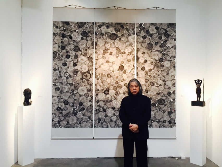 Huang I-Ming stands in front of his artworks, shown at Gallery Sun at Art Stage